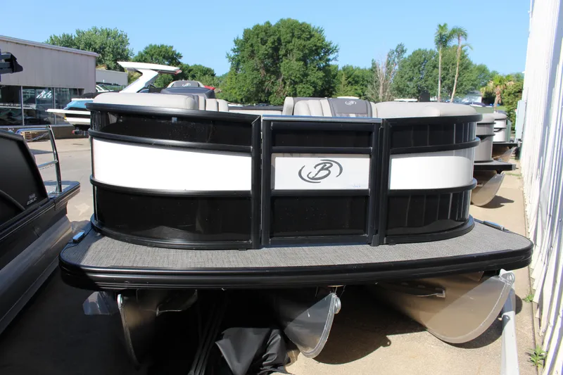 Slide: The Image of 2025 Barletta Lusso 23U pontoon boat with sleek black and white design, docked outdoors. - 3