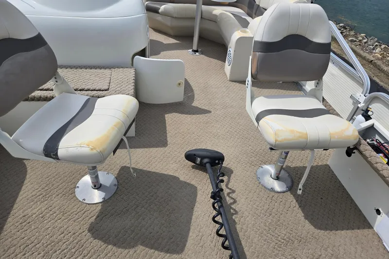 Slide: The Image of 2007 Suncruiser Trinidad 204 boat interior with worn seats and carpeted deck. - 10