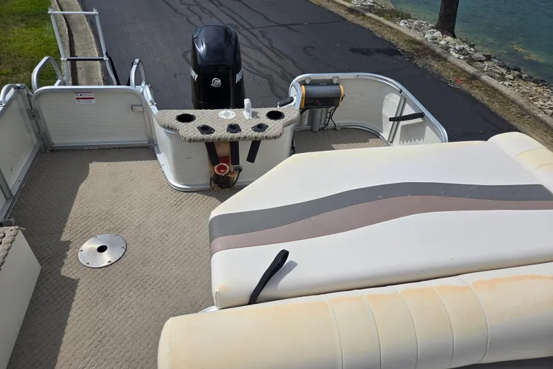 Slide: The Image of 2007 Suncruiser Trinidad 204 pontoon boat interior with seating and motor, near water. - 18