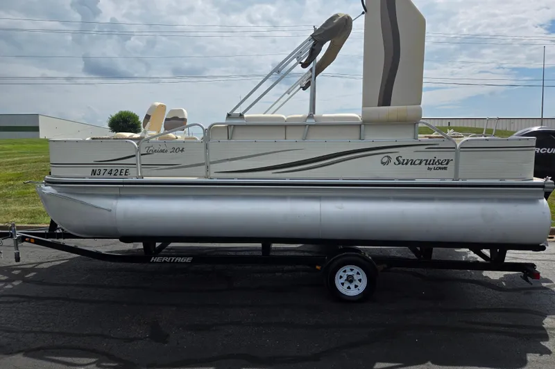 Slide: The Image of 2007 Suncruiser Trinidad 204 pontoon boat on trailer, parked outdoors. - 4