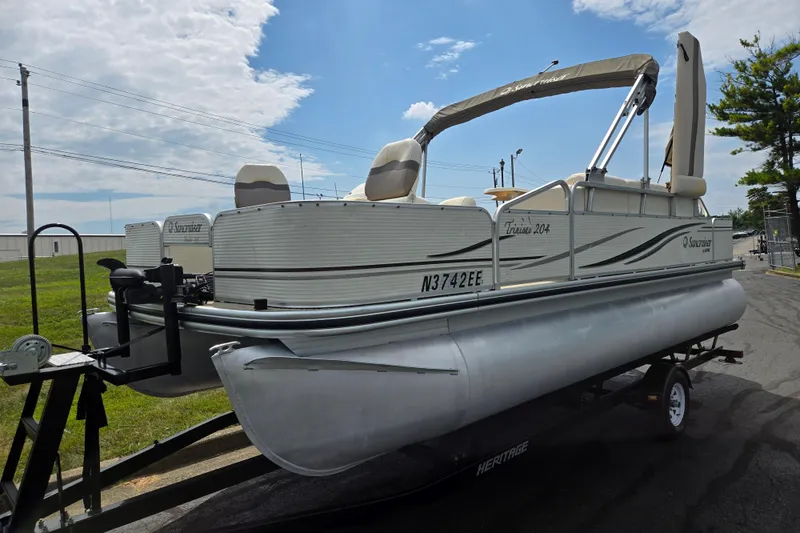 Slide: The Image of 2007 Suncruiser Trinidad 204 pontoon boat on trailer, parked outdoors under blue sky. - 5