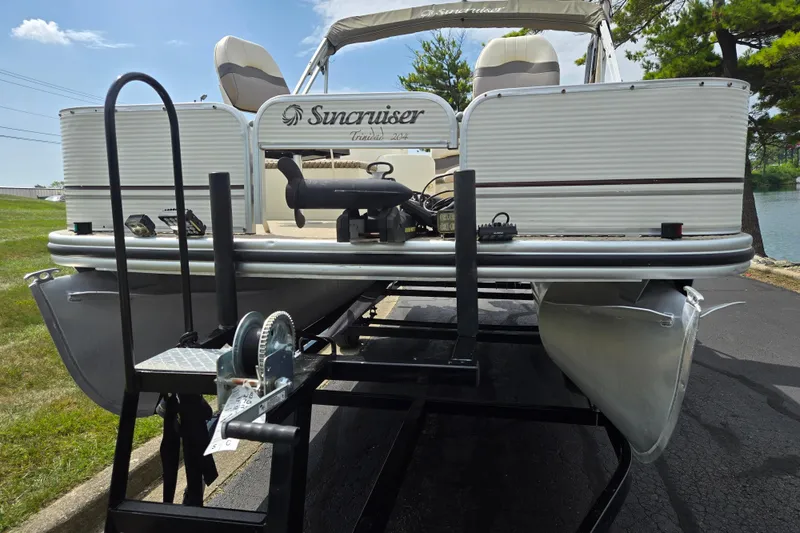 Slide: The Image of 2007 Suncruiser Trinidad 204 pontoon boat on trailer, parked near a lake. - 6