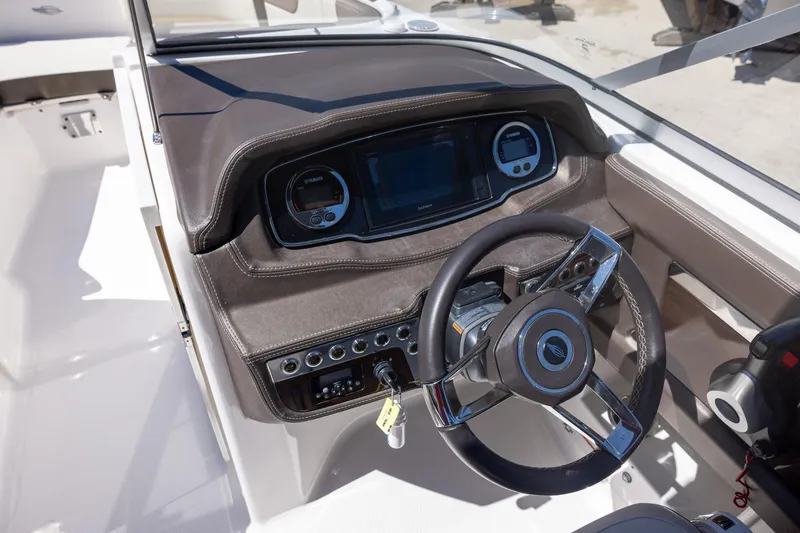 Slide: The Image of 2019 Chaparral 230 Suncoast boat dashboard with steering wheel and control panel. - 10