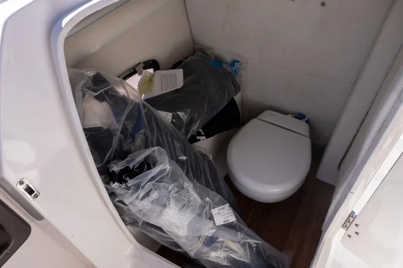 Slide: The Image of Interior of 2019 Chaparral 230 Suncoast boat with toilet and stored items. - 12