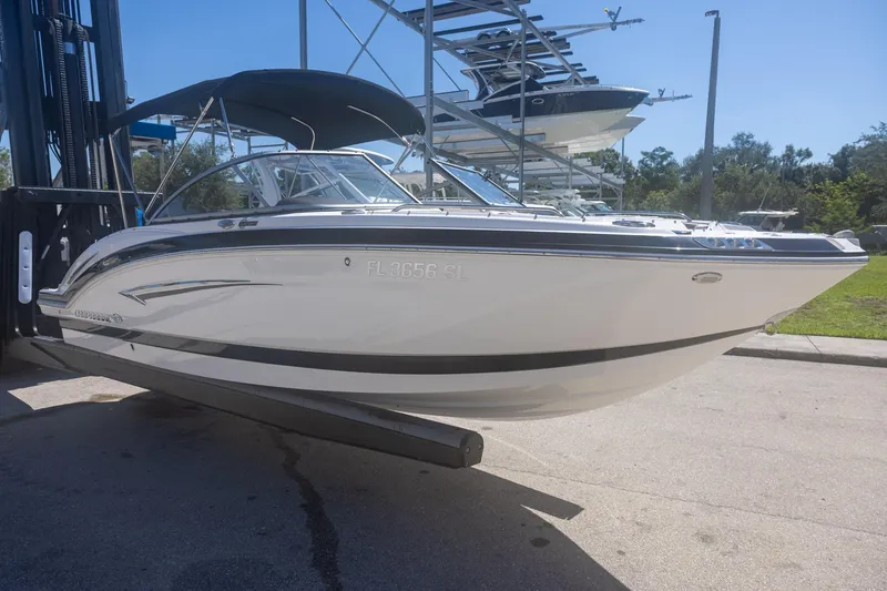 Slide: The Image of 2019 Chaparral 230 Suncoast boat on a lift, sleek design, sunny day. - 3