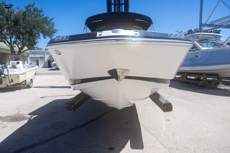 Slide: The Image of 2019 Chaparral 230 Suncoast boat on trailer, parked outdoors under clear blue sky. - 5
