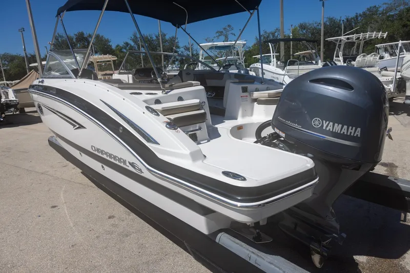 Slide: The Image of 2019 Chaparral 230 Suncoast boat with Yamaha outboard motor, docked outdoors. - 6