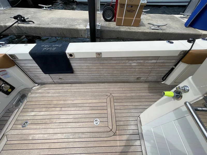Slide: The Image of 2020 Scout 530 LXF boat deck with teak flooring and dockside view. - 29