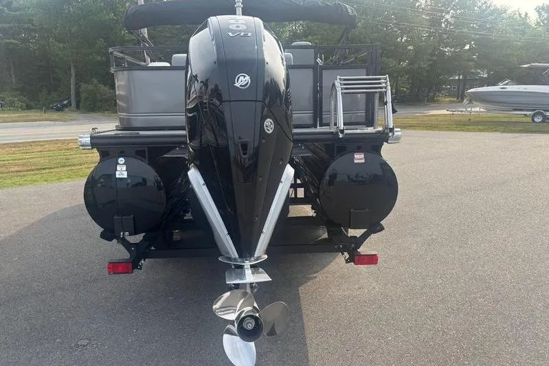 Slide: The Image of 2025 Regency 250 DL3 pontoon boat with powerful outboard motor, parked on pavement. - 8