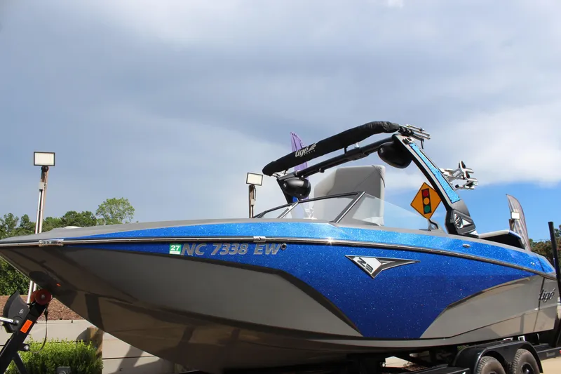 Slide: The Image of 2022 Tigé Z3 boat with blue exterior on a trailer under a cloudy sky. - 7