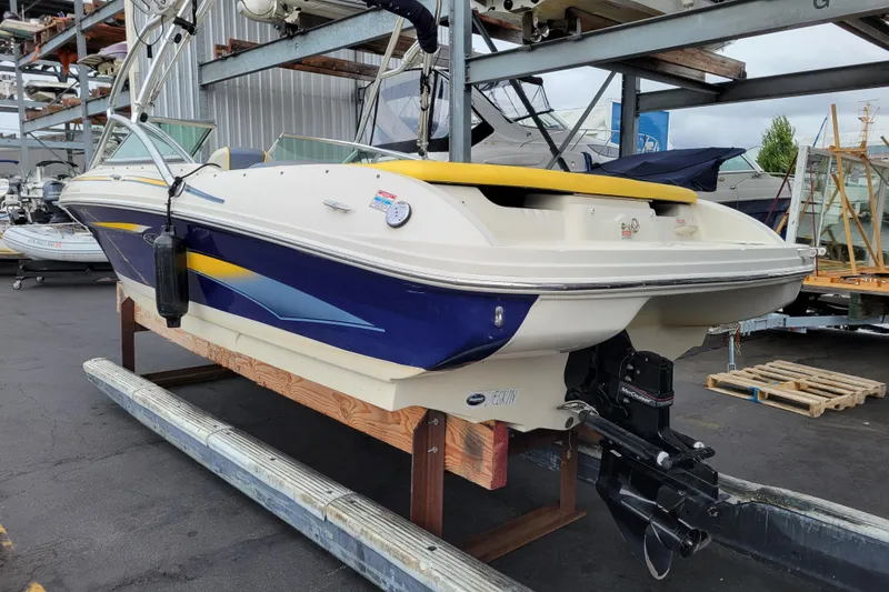 Slide: The Image of 2006 Sea Ray 205 Sport boat docked at marina, featuring sleek design and yellow interior accents. - 2