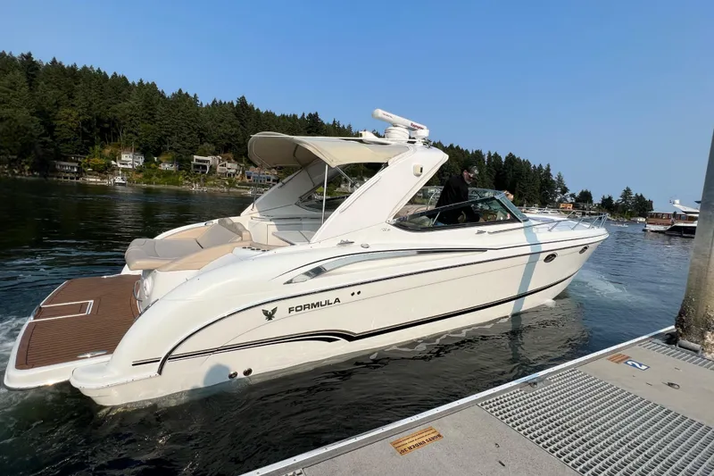 Slide: The Image of 2011 Formula 400 Super Sport boat docked on a serene lake with forested background. - 2