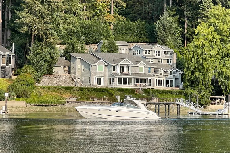 Slide: The Image of 2011 Formula 400 Super Sport boat cruising near waterfront homes and lush greenery. - 3