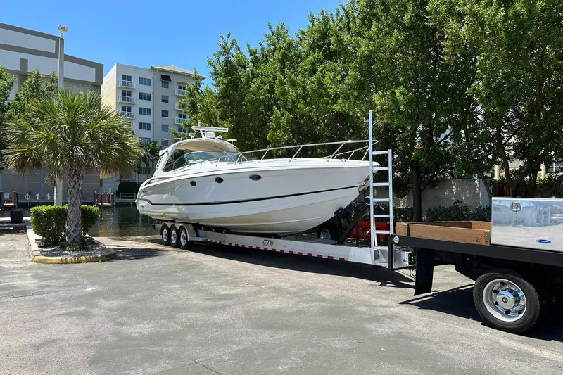 Slide: The Image of 2011 Formula 400 Super Sport boat on trailer, parked near buildings and trees. - 5