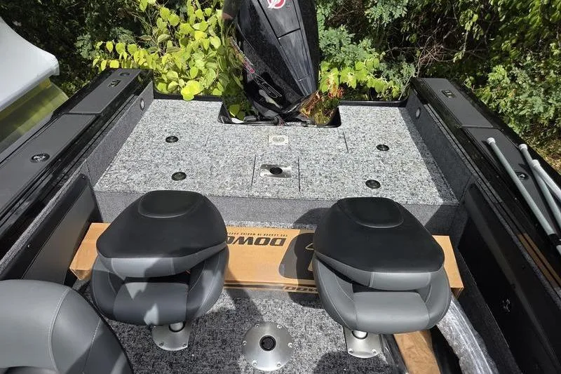 Slide: The Image of 2026 Tracker Targa™ V-19 WT boat interior with dual seats and motor, surrounded by greenery. - 12