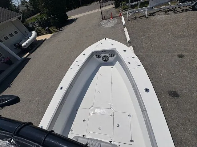 Slide: The Image of 2025 Latitude Tournament Boats 25, sleek white deck, parked outdoors. - 13