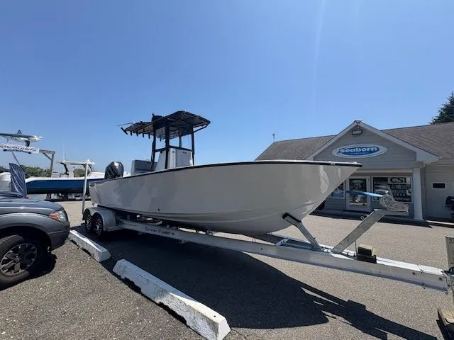 Slide: The Image of 2025 Latitude Tournament Boats 25 on trailer outside dealership under clear blue sky. - 2