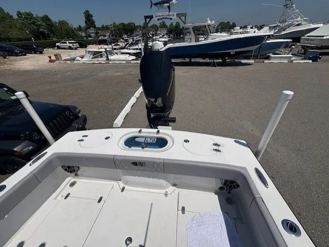 Slide: The Image of 2025 Latitude Tournament Boats 25 at marina, showcasing spacious deck and powerful outboard motor. - 9