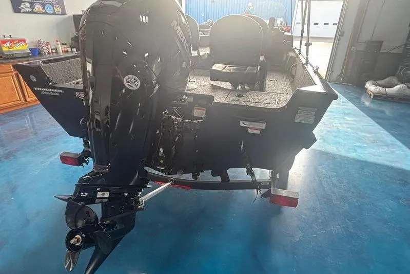 Slide: The Image of 2026 Tracker PG V16 SC boat with Mercury outboard motor in a garage setting. - 3