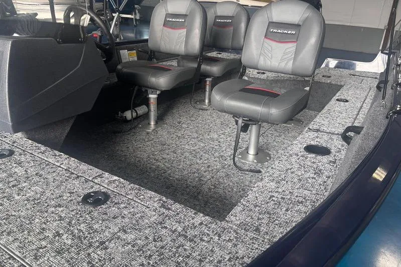 Slide: The Image of Interior of 2026 Tracker PG V16 SC boat with gray seating and carpeted flooring. - 6