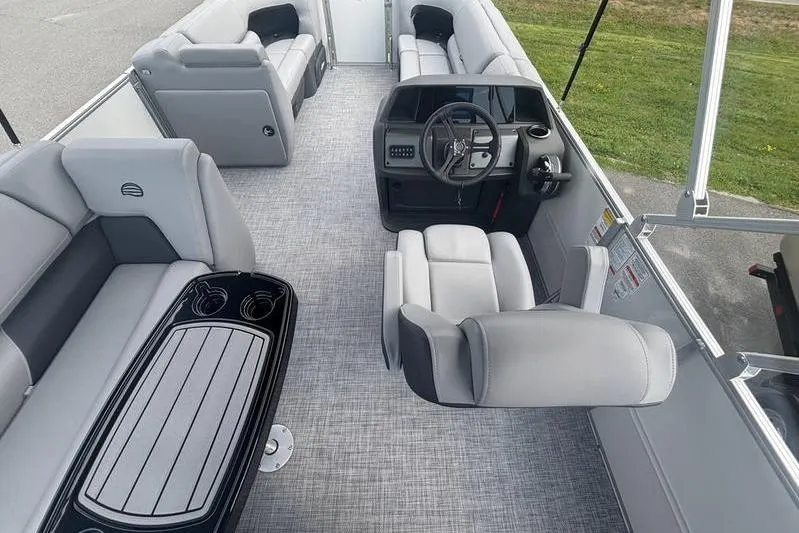 Slide: The Image of 2026 Sun Tracker PB 20 DLX pontoon boat interior with gray seating and steering console. - 3