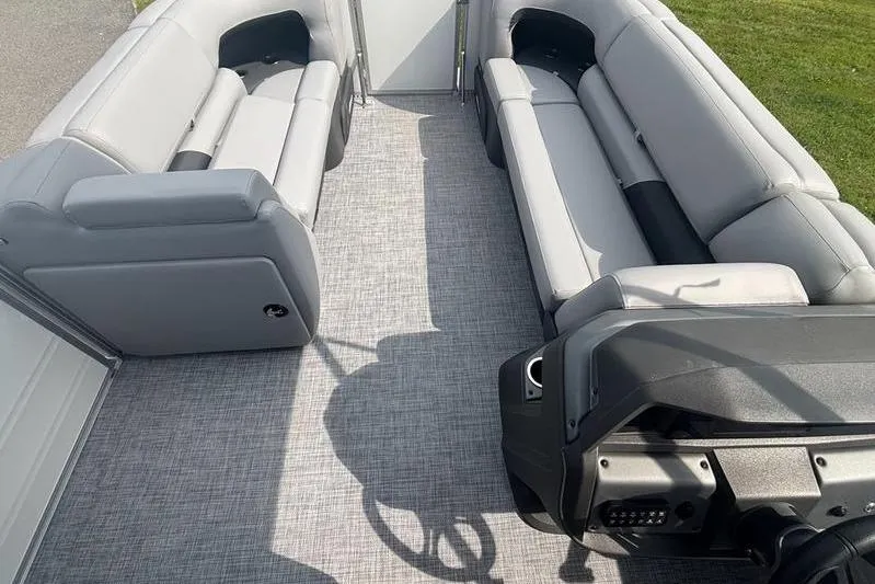 Slide: The Image of 2026 Sun Tracker PB 20 DLX pontoon boat interior with gray seating and steering console. - 6