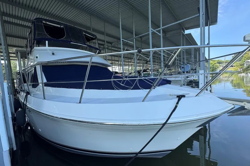 Slide: The Image of 1998 Carver 405 Motor Yacht docked under a covered marina. - 1