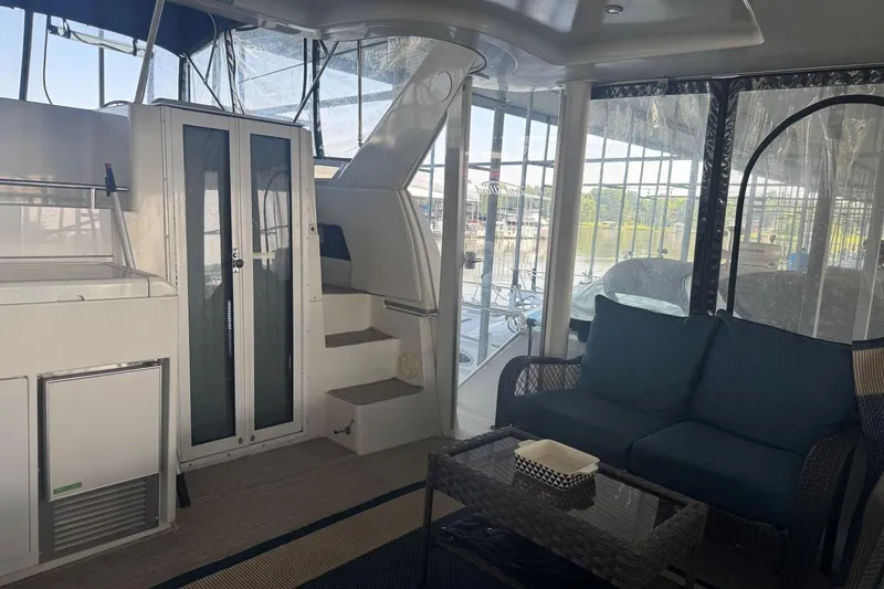 Slide: The Image of Interior of 1998 Carver 405 Motor Yacht with seating and stairs, featuring large windows. - 15