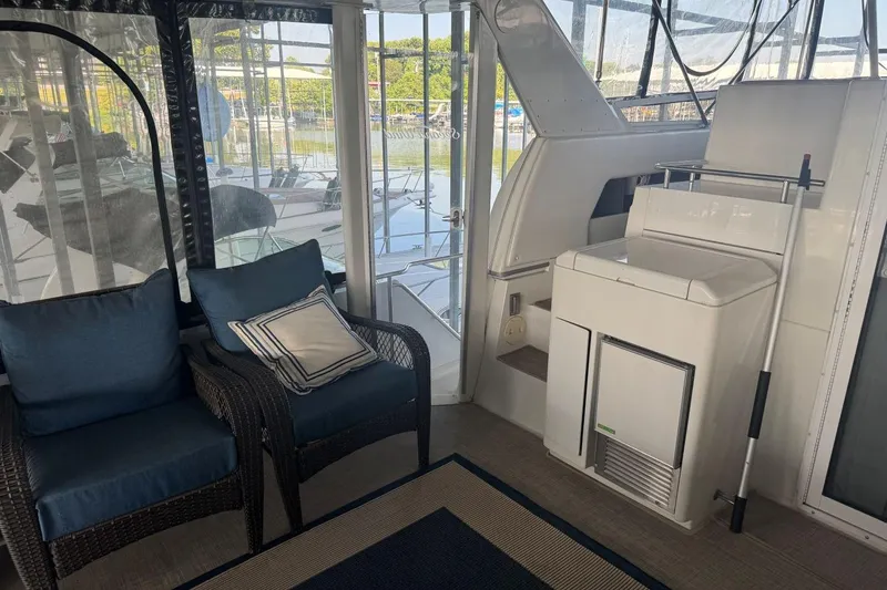 Slide: The Image of 1998 Carver 405 Motor Yacht interior with seating and storage, overlooking marina. - 16