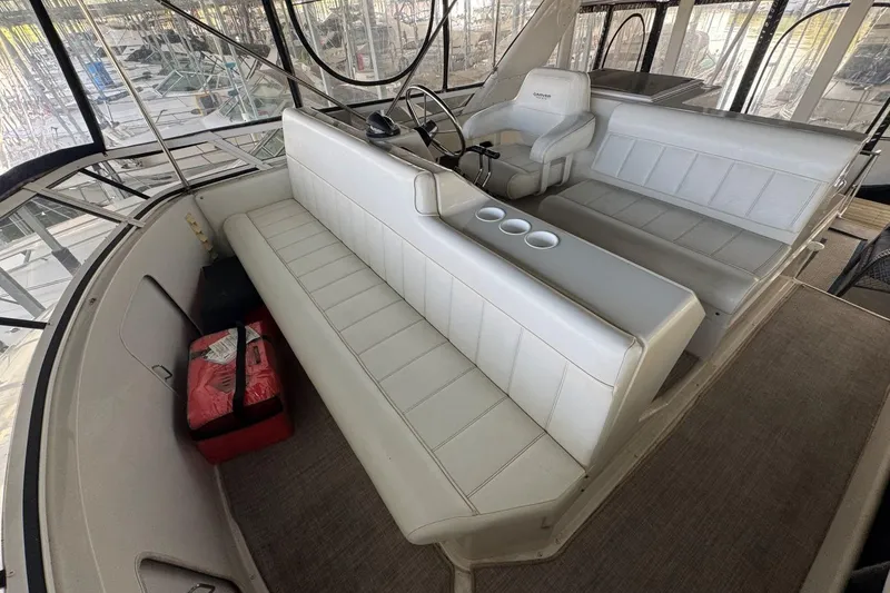 Slide: The Image of 1998 Carver 405 Motor Yacht interior with white seating and helm station. - 24