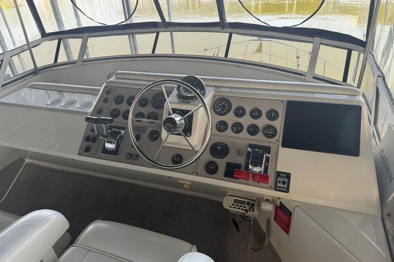 Slide: The Image of 1998 Carver 405 Motor Yacht helm with steering wheel, gauges, and navigation equipment. - 26