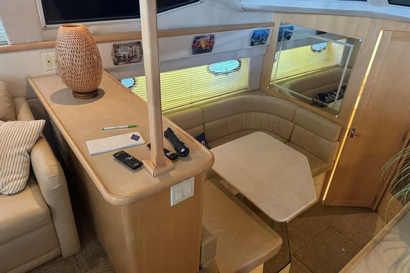 Slide: The Image of 1998 Carver 405 Motor Yacht interior with cozy seating and table setup. - 37