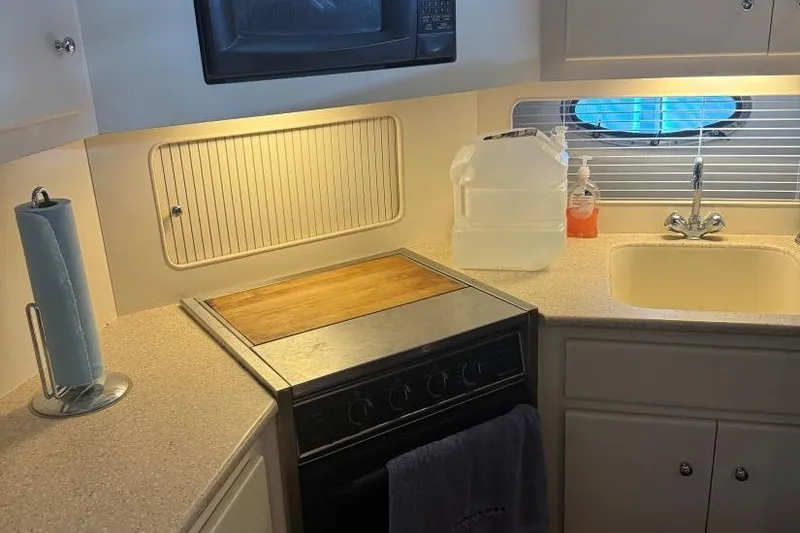 Slide: The Image of Compact kitchen in a 1998 Carver 405 Motor Yacht with stove, sink, and microwave. - 42