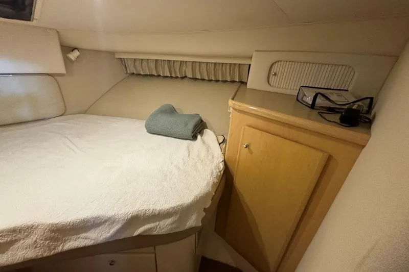 Slide: The Image of 1998 Carver 405 Motor Yacht cabin with bed, cabinet, and folded towel. - 45