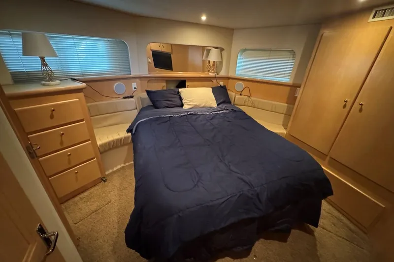 Slide: The Image of Luxurious bedroom interior of 1998 Carver 405 Motor Yacht with cozy bed and wooden cabinetry. - 50