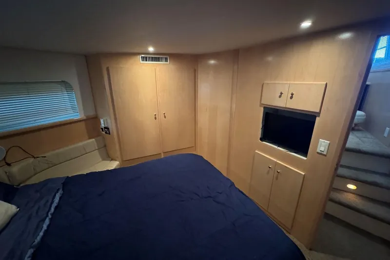 Slide: The Image of Luxurious bedroom interior of 1998 Carver 405 Motor Yacht with wood paneling and cozy lighting. - 51