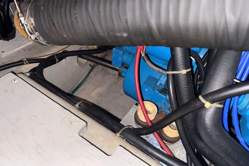 Slide: The Image of Engine compartment of a 1998 Carver 405 Motor Yacht with visible hoses and wiring. - 61