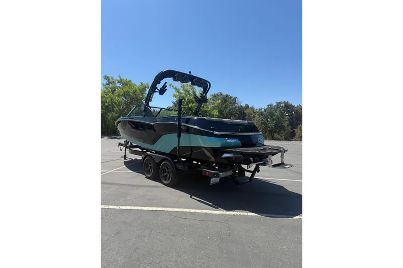 Slide: The Image of 2025 MasterCraft NXT22 boat on trailer in sunny parking lot. - 1