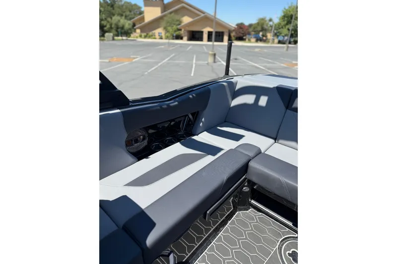 Slide: The Image of 2025 MasterCraft NXT22 boat interior with gray seating and cup holders. - 11