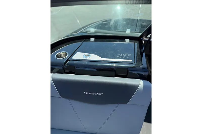 Slide: The Image of 2025 MasterCraft NXT22 boat interior with sleek seating and cup holder. - 19