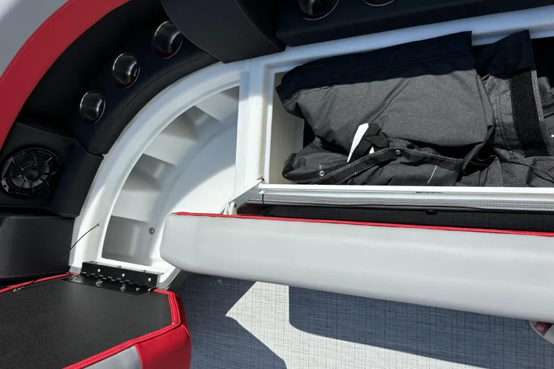 Slide: The Image of 2026 Berkshire 24RFX CTS boat interior storage compartment with black fabric items. - 14