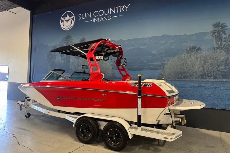 Slide: The Image of 2019 Nautique Super Air Nautique GS20 boat in showroom, red and white design, on trailer. - 3