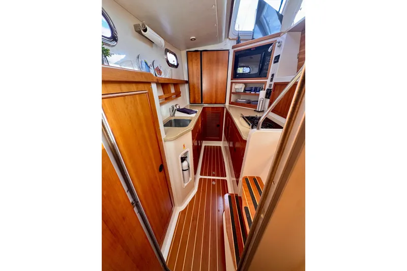 Slide: The Image of 2006 PDQ PowerCat interior with wooden cabinetry, compact kitchen, and modern appliances. - 11