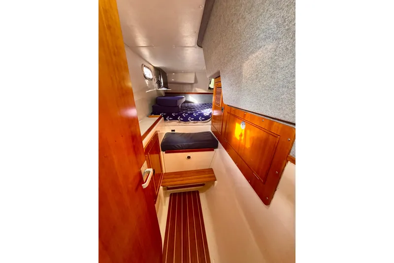 Slide: The Image of Interior cabin of 2006 PDQ PowerCat with wooden accents and cozy bedding. - 16