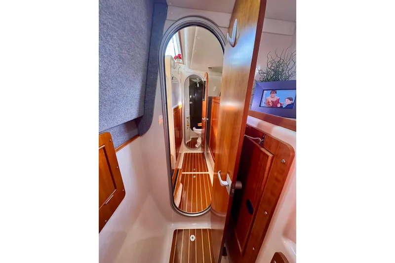 Slide: The Image of Interior of 2006 PDQ PowerCat boat with wooden finishes and hallway view. - 17