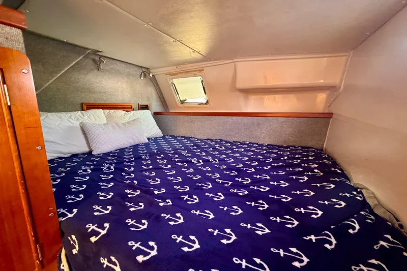 Slide: The Image of Cozy cabin interior of 2006 PDQ PowerCat with anchor-patterned bedding. - 19