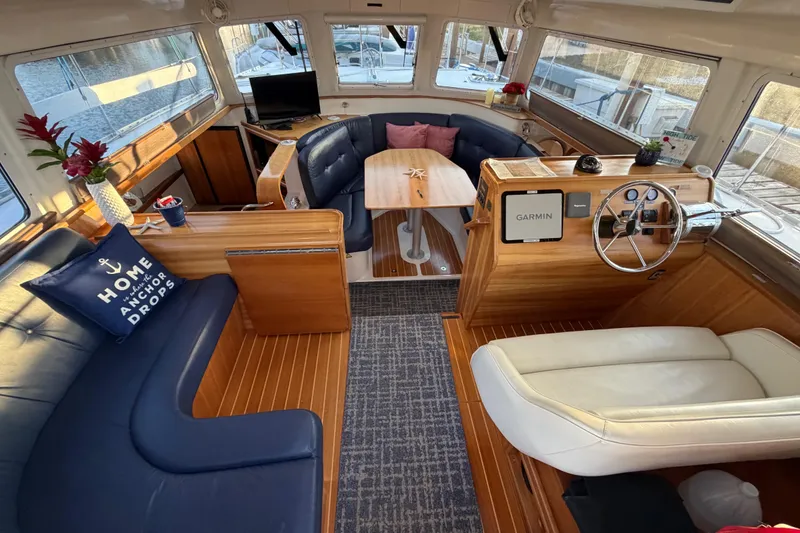 Slide: The Image of Interior of 2006 PDQ PowerCat boat with cozy seating and wooden accents. - 2