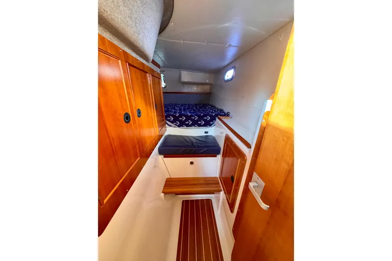 Slide: The Image of 2006 PDQ PowerCat cabin interior with wooden cabinetry and nautical-themed bedding. - 20