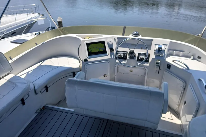 Slide: The Image of 2006 PDQ PowerCat boat helm with steering wheel, navigation screen, and seating. - 21