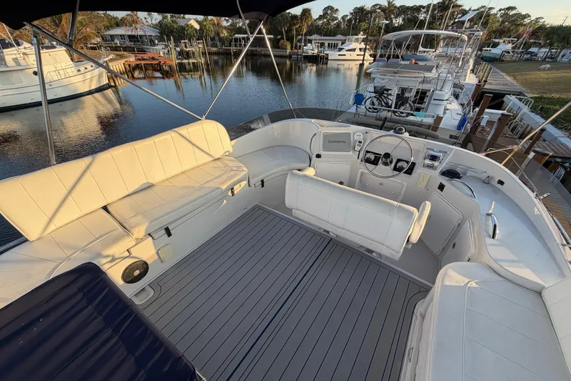 Slide: The Image of 2006 PDQ PowerCat boat interior with white seating and steering wheel, docked at marina. - 22